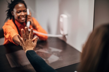 Two women, female prisoner talking over the phone
