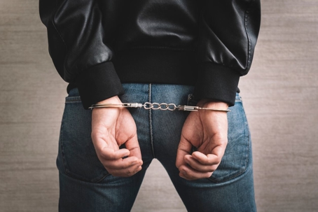 Arrested man handcuffed hands at the back.