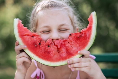 girl have fun eating watermelon